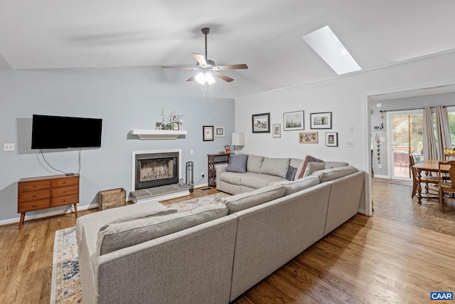 6 Axle Tree Rd, Palmyra, VA 22963 - living area featuring lofted ceiling, wood finished floors, a skylight, a ceiling fan, and a fireplace with raised hearth