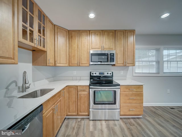 625 Butler Ave, Winchester, VA 22601 - kitchen featuring appliances with stainless steel finishes, a sink, light stone counters, light wood-style floors, and glass insert cabinets