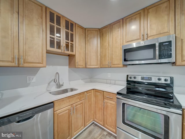 625 Butler Ave, Winchester, VA 22601 - kitchen featuring appliances with stainless steel finishes, a sink, glass insert cabinets, light wood-type flooring, and light stone countertops