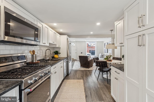106 Bainbridge St, Philadelphia, PA 19147 - kitchen with appliances with stainless steel finishes, a sink, dark wood-type flooring, white cabinets, and backsplash