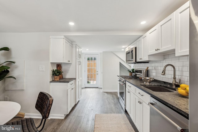 106 Bainbridge St, Philadelphia, PA 19147 - kitchen featuring a sink, stainless steel appliances, dark countertops, baseboards, and recessed lighting