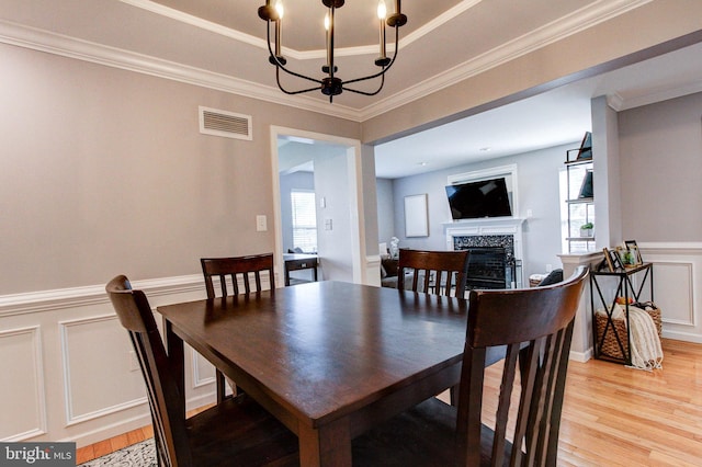 812 Red Rock Cir, Royersford, PA 19468 - dining space featuring a chandelier, light wood finished floors, plenty of natural light, a decorative wall, and a wainscoted wall