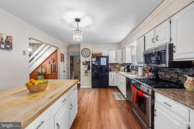 312 Walnut Ave, Marlton, NJ 08053 - kitchen with stainless steel appliances, a sink, butcher block counters, white cabinetry, and backsplash