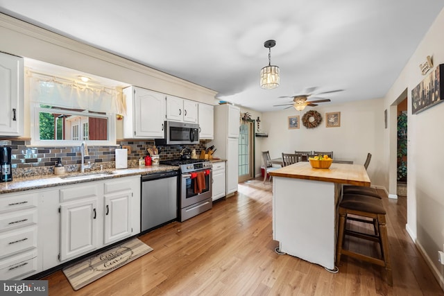 312 Walnut Ave, Marlton, NJ 08053 - kitchen with a sink, stainless steel appliances, ceiling fan, backsplash, and light wood-type flooring