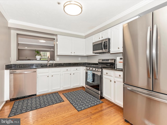 20523 Staffordshire Dr, Germantown, MD 20874 - kitchen featuring stainless steel appliances, a sink, crown molding, white cabinetry, and light wood-style flooring