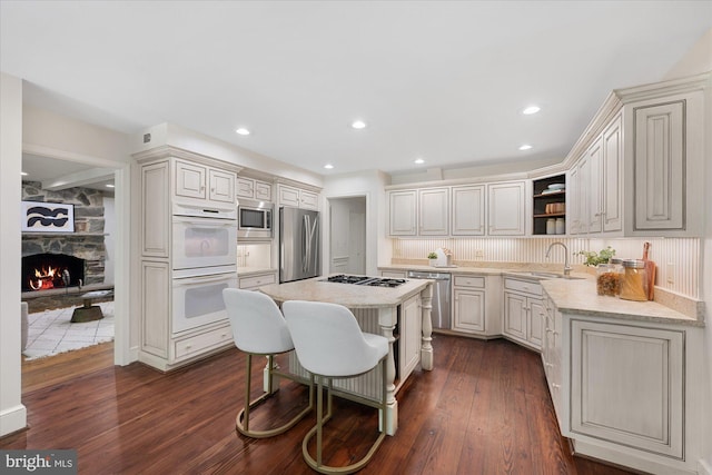 1091 Old Cedar Rd, Mclean, VA 22102 - kitchen featuring appliances with stainless steel finishes, a sink, open shelves, dark wood finished floors, and a breakfast bar area
