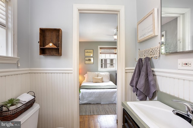 4407 Sedgwick Rd, Baltimore, MD 21210 - ensuite bathroom featuring wainscoting, wood finished floors, vanity, and a ceiling fan