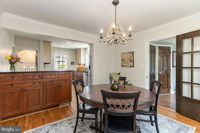 4407 Sedgwick Rd, Baltimore, MD 21210 - dining space with a chandelier, light wood finished floors, and crown molding