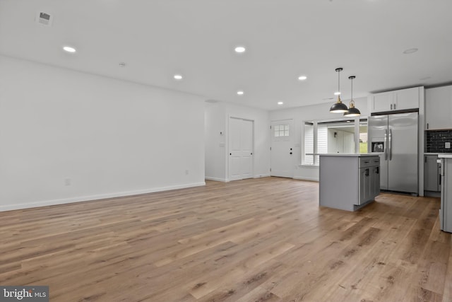 1 Mimosa Ln, Levittown, PA 19054 - kitchen with stainless steel fridge with ice dispenser, light wood-type flooring, a center island, decorative backsplash, and hanging light fixtures