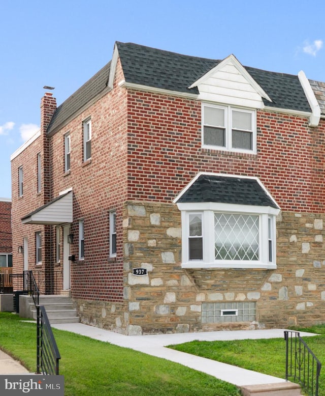 937 E Durard St, Philadelphia, PA 19150 - view of front facade with roof with shingles, stone siding, a front yard, and brick siding