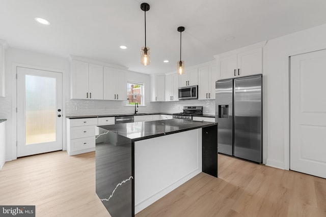 937 E Durard St, Philadelphia, PA 19150 - kitchen with appliances with stainless steel finishes, light wood finished floors, dark countertops, white cabinets, and backsplash