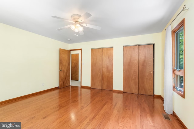 5305 Thunder Hill Rd, Columbia, MD 21045 - unfurnished bedroom with light wood finished floors, multiple closets, baseboards, and a ceiling fan