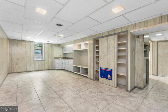 5305 Thunder Hill Rd, Columbia, MD 21045 - unfurnished living room with wood walls, a sink, and a paneled ceiling