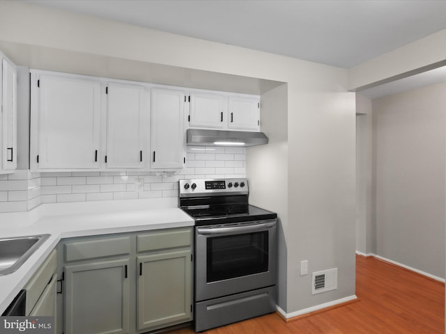 108 Bickel Ct, Sterling, VA 20165 - kitchen with electric range, under cabinet range hood, baseboards, and backsplash
