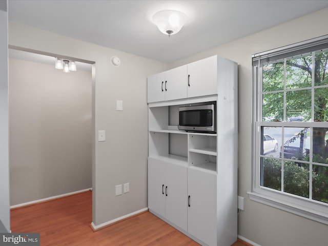 108 Bickel Ct, Sterling, VA 20165 - kitchen featuring stainless steel microwave, light wood-style flooring, white cabinets, and baseboards