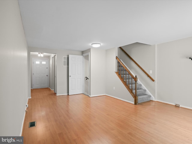 108 Bickel Ct, Sterling, VA 20165 - unfurnished living room with light wood-style floors, stairway, and baseboards