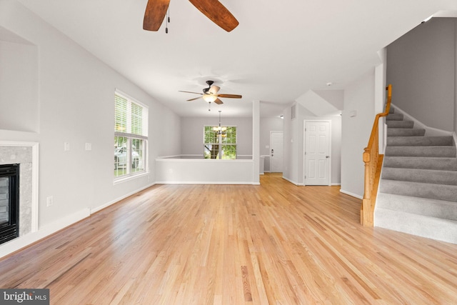 45620 Livingstone Station St, Sterling, VA 20166 - unfurnished living room featuring a ceiling fan, light wood-style floors, a tile fireplace, and baseboards