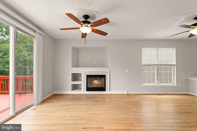 45620 Livingstone Station St, Sterling, VA 20166 - unfurnished living room with ceiling fan, a glass covered fireplace, wood finished floors, and built in shelves