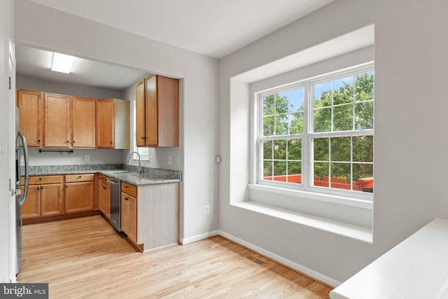 45620 Livingstone Station St, Sterling, VA 20166 - kitchen with appliances with stainless steel finishes, a sink, light wood finished floors, baseboards, and light stone countertops