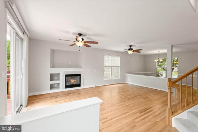 45620 Livingstone Station St, Sterling, VA 20166 - unfurnished living room with light wood-type flooring, ceiling fan, and a glass covered fireplace