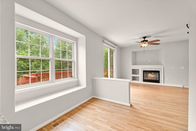 45620 Livingstone Station St, Sterling, VA 20166 - unfurnished living room featuring light wood-style flooring, a ceiling fan, baseboards, and a glass covered fireplace