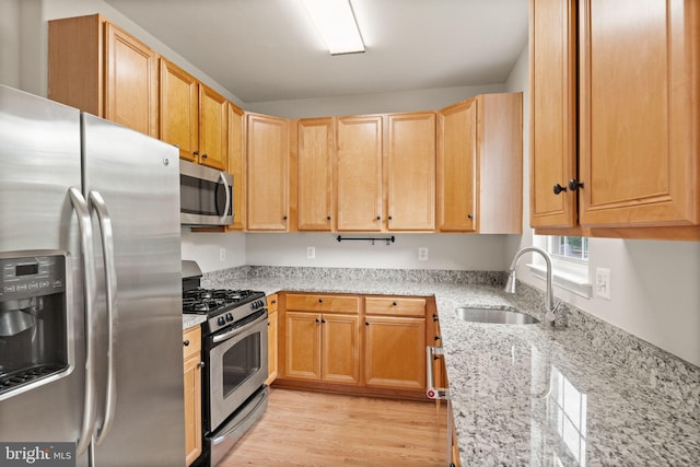 45620 Livingstone Station St, Sterling, VA 20166 - kitchen featuring stainless steel appliances, a sink, light stone countertops, light wood finished floors, and light brown cabinets