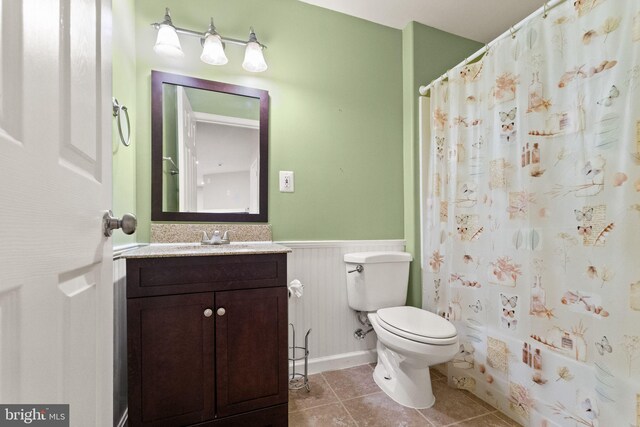 45620 Livingstone Station St, Sterling, VA 20166 - full bathroom featuring wainscoting, toilet, vanity, tile patterned floors, and a shower with shower curtain