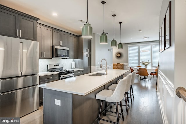 1009 Lakeview Ct Unit 1009, King Of Prussia, PA 19406 - kitchen featuring stainless steel appliances, a sink, a center island with sink, a breakfast bar area, and decorative backsplash