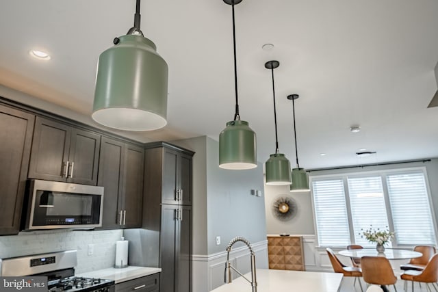 1009 Lakeview Ct Unit 1009, King Of Prussia, PA 19406 - kitchen with stainless steel microwave, gas stove, light countertops, decorative backsplash, and wainscoting