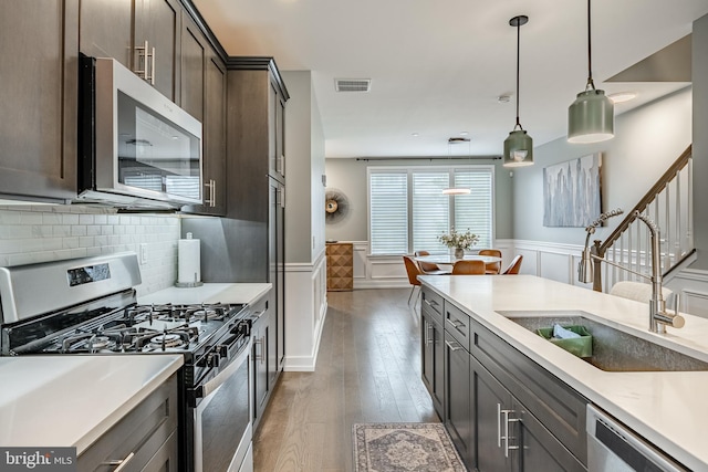 1009 Lakeview Ct Unit 1009, King Of Prussia, PA 19406 - kitchen featuring appliances with stainless steel finishes, a sink, a wainscoted wall, a decorative wall, and hardwood / wood-style floors