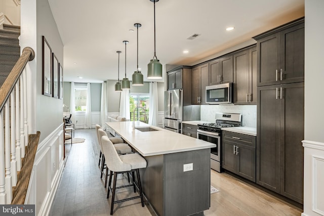 1009 Lakeview Ct Unit 1009, King Of Prussia, PA 19406 - kitchen with stainless steel appliances, a sink, dark brown cabinetry, a decorative wall, and light countertops