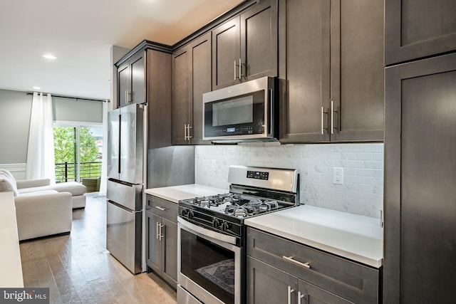 1009 Lakeview Ct Unit 1009, King Of Prussia, PA 19406 - kitchen featuring appliances with stainless steel finishes, dark brown cabinets, light countertops, light wood finished floors, and tasteful backsplash