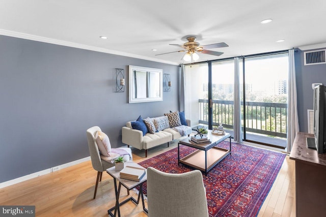 living room featuring ceiling fan, wood finished floors, ornamental molding, recessed lighting, and a wall of windows