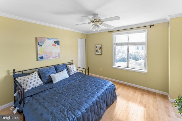 bedroom with baseboards, light wood-style floors, crown molding, and ceiling fan