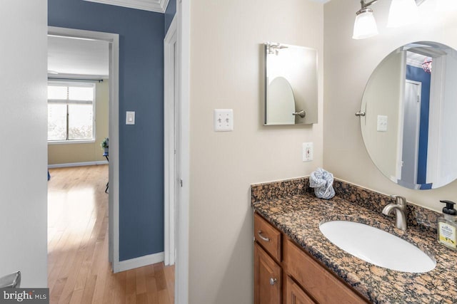 bathroom featuring wood finished floors, vanity, and baseboards