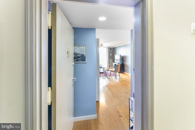 hallway featuring baseboards and wood finished floors