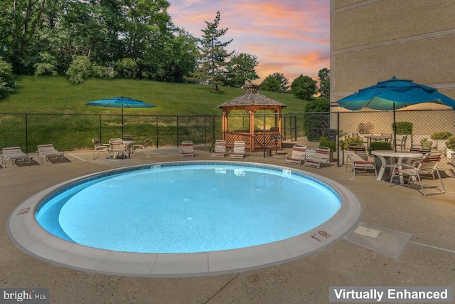 community pool with a gazebo and a patio area