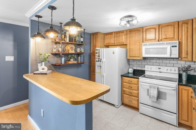 kitchen with white appliances, backsplash, crown molding, hanging light fixtures, and baseboards