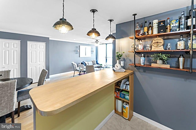 bar with baseboards, ceiling fan, pendant lighting, and crown molding