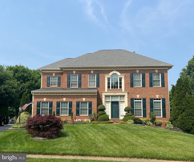 4054 Sapling Way, Triangle, VA 22172 - georgian-style home with brick siding, a front lawn, and roof with shingles