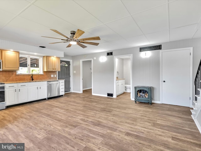 20 E Market St, Schuylkill Haven, PA 17972 - kitchen with stainless steel dishwasher, baseboards, a wood stove, ceiling fan, and tasteful backsplash