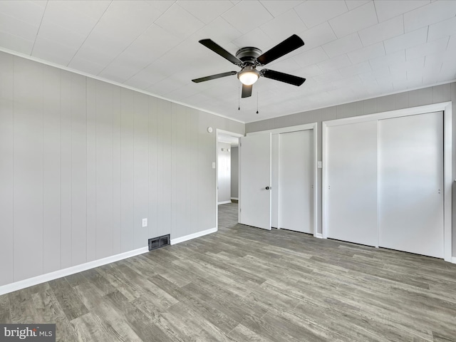 20 E Market St, Schuylkill Haven, PA 17972 - unfurnished bedroom with multiple closets, wood finished floors, baseboards, and a ceiling fan