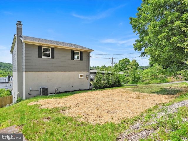 20 E Market St, Schuylkill Haven, PA 17972 - view of side of property featuring a chimney, central AC, and a shingled roof