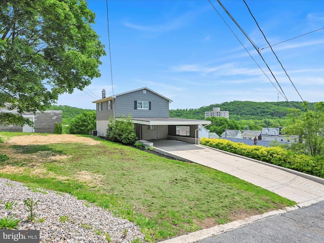 20 E Market St, Schuylkill Haven, PA 17972 - view of front facade with concrete driveway, an attached carport, a front yard, and a chimney