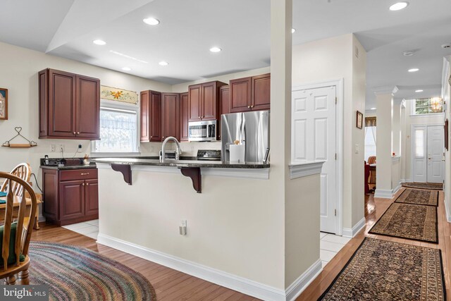 230 Bobwhite Rd, New Hope, PA 18938 - kitchen with stainless steel appliances, a breakfast bar area, light wood-type flooring, recessed lighting, and a sink