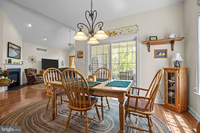 230 Bobwhite Rd, New Hope, PA 18938 - dining area with vaulted ceiling, light wood-style flooring, a fireplace with flush hearth, a chandelier, and baseboards