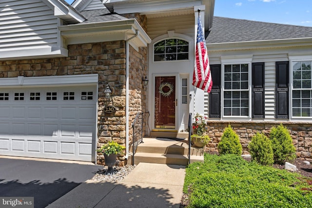 230 Bobwhite Rd, New Hope, PA 18938 - property entrance with stone siding, a shingled roof, a garage, and asphalt driveway