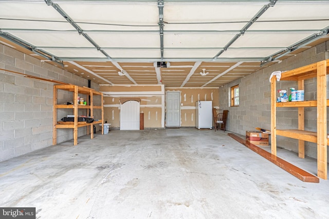 1627 Kindle Ave, Deptford, NJ 08096 - garage featuring a garage door opener, freestanding refrigerator, and concrete block wall