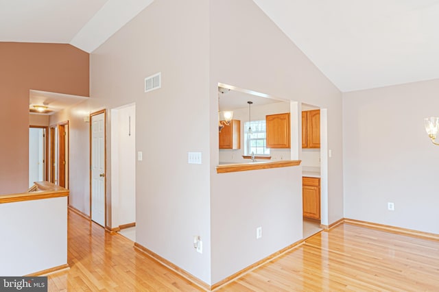 1627 Kindle Ave, Deptford, NJ 08096 - unfurnished living room with high vaulted ceiling, light wood-type flooring, baseboards, and a chandelier