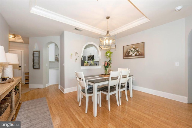 2500 Waterside Dr Unit 110, Frederick, MD 21701 - dining room with arched walkways, a raised ceiling, light wood finished floors, ornamental molding, and baseboards